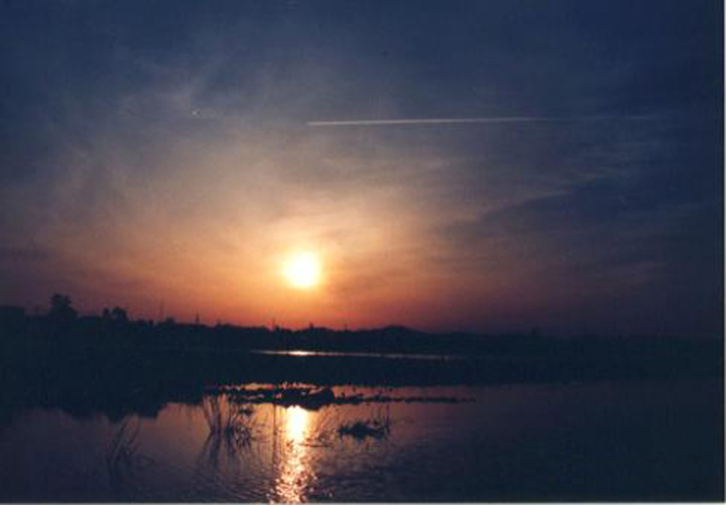 夕陽と飛行機雲｜赤川河川敷、羽黒側(現：ブルボン工場付近)から鶴岡市内方向